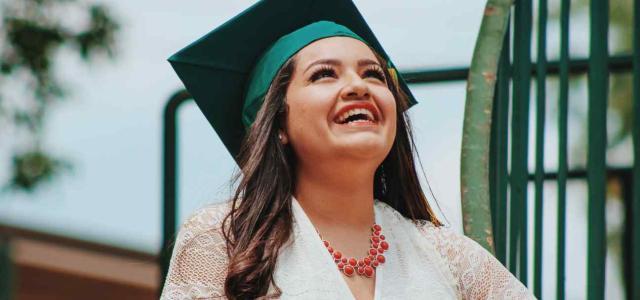 Woman with graduation cap looking at the sky